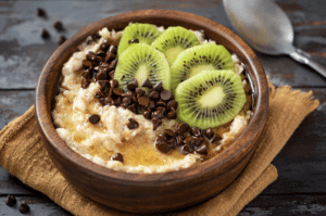 Bol de porridge au kiwi illustrant les meilleurs aliments contre la fatigue chronique et le manque d'énergie
