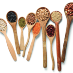 Cuillères remplies de lentilles, pois chiches et haricots illustrant les bienfaits des légumineuses pour la santé et l'alimentation