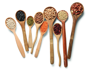 Cuillères remplies de lentilles, pois chiches et haricots illustrant les bienfaits des légumineuses pour la santé et l'alimentation